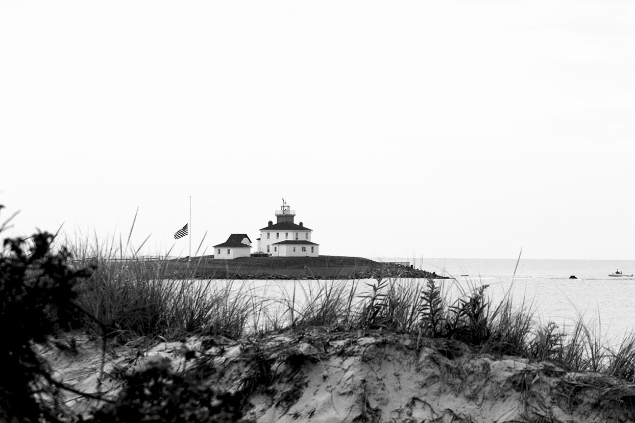 Haile Ratajack: 'Watch Hill Lighthouse', 2022 Black and White Photograph, Landscape. Landscape shot of the Watch Hill Lighthouse in Rhode Island featuring a flag at half mass.  ...