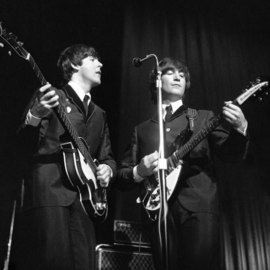Paul Berriff: 'The Beatles Unified', 1963 Black and White Photograph, Music. Artist Description:  Paul McCartney and John Lennon on stage at the ABC Theater in Huddersfield Yorkshire during their first tour of the UK on 29 November 1963.  They are performing for the first time live I Want To Hold Your Hand which had been released the same day.  This is ...