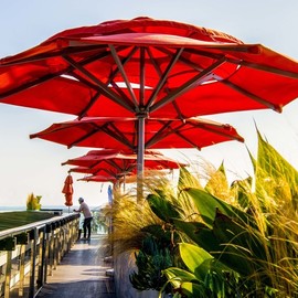 Dick Drechsler: 'the umbrellas of venice', 2018 Color Photograph, Urban. Artist Description: Towering over the Pacific Ocean this restaurant shelters its patrons from the sun with these colorful red umbrellas. ...