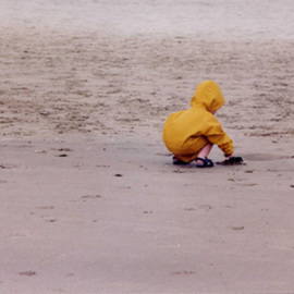 Ruth Zachary: 'Childs Play', 2004 Color Photograph, Children. Artist Description:  Little- one ( boy or girl seen from the back) in bright yellow slicker playing at the seaside on the sand.  Simple composition. Sweet and charming. Cannon Beach, OR.  11 x 14